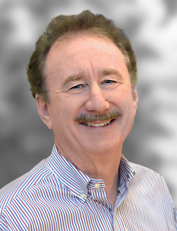 A portrait of Ed Solomon, a smiling man with a mustache wearing a striped shirt.