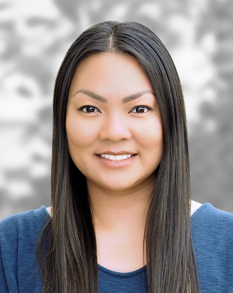 A portrait of Linh Vuong, a smiling woman with long straight hair against a gray background.