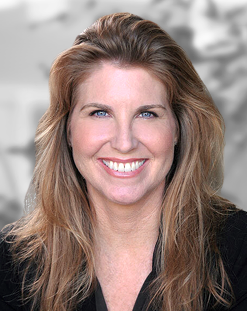 A portrait of a Loretta Hillberry, a smiling woman with long hair against a blurred background.