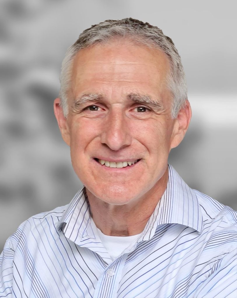 A portrait of Tobias Funk, a smiling man with grey hair wearing a striped shirt against a blurred background.